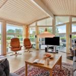 Living room with wooden ceiling, seating, and view of the terrace.