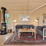 Living room with wood walls, fireplace, sofa, and rug.