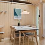 Dining room with wooden walls, table and chairs, view of the garden.
