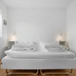 Ein Schlafzimmer mit einem Bett, zwei Nachttischen und einem Fenster.