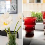 Weiße Blumen in einem Glas auf Tisch. Rote Gläser und Blumen auf Balkon.