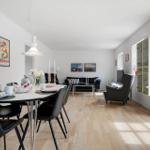 Esszimmer mit Tisch und Stühlen. Wohnbereich mit Sofa, Sessel und Wandbildern.
