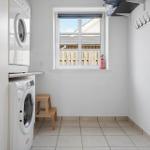 Wäscherei mit Waschmaschine, Trockner und Fenster