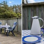 Terrasse mit Tisch, zwei Stühlen und Holzgeländer. Tisch mit Tischdecke und Geschirr.