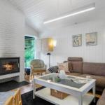 Living room with sofa, fireplace, and glass-top table. Bookshelf and wall art visible.