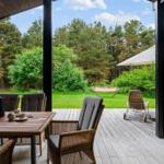 Terrace with seating group, table, and view into the forest.