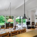 Dining room with wooden table, chairs, and large windows to the garden