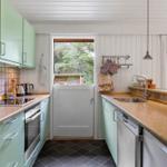 Kitchen with green cabinets, countertops, and view of the garden.