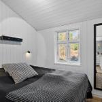 Schlafzimmer mit Bett, Fenster und Spiegel. Wände und Decke sind weiß verputzt.