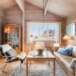 Wohnzimmer mit Holzwand, Sofa, Sessel und Tisch