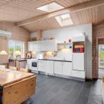 Küche mit Essbereich und Schlafzimmer im Hintergrund. Holzdecke, Fenster und Küchenzeile.