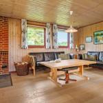 Wohnzimmer mit Holzfußboden, Sofa, Tisch und Kaminofen an Backsteinwand.