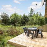 Terrasse mit Tisch und Stühlen, Blick auf Wald und Himmel