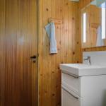 Badezimmer mit Holzwand, Waschbecken und Spiegel