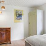 Schlafzimmer mit Bett, Kleiderschrank und Holzschrank. An der Wand hängt ein Bild.