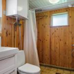 Badezimmer mit Holzwand, Dusche, Waschbecken und Toilette