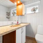 Badezimmer mit Waschbecken, Spiegel, Toilette und Fenster