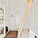 Eingangsbereich mit Holztreppe, Teppich und Waschmaschine