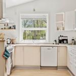 Küche mit Fenster, Spüle, Kühlschrank und Waschmaschine.