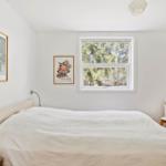 Schlafzimmer mit Bett, Fenster und Stuhl