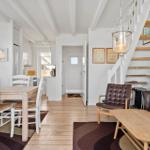 Wohnung mit Essbereich, Holzfußboden und Treppe zur oberen Etage.