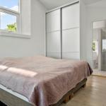 Bedroom with bed, closet, and window. Bathroom is adjacent.