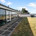 Modern villa with large glass area and garden. View of sea and sky.