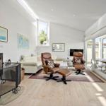 Living room with fireplace, leather chairs, and terrace