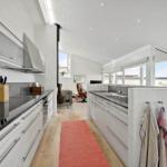 Modern kitchen with view to living area and terrace.