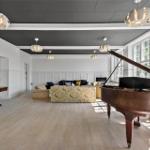 Großer Raum mit Flur, Sofa, Klavier und Deckenleuchten.