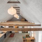 Haus mit Holzkonstruktion, Küchenbereich und Wohnfläche unter Dachschrägen.