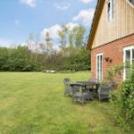 Haus mit Garten, Tisch und Stühlen, umgeben von Bäumen und Gras.