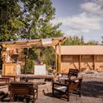 Außenbereich mit Loungebereich, Grillstation und Zeltunterkunft.
