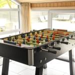 Fußballtisch im Innenbereich mit Blick auf den Außenbereich.