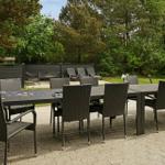 Terrasse mit Esstisch und Stühlen, umgeben von Grünfläche und Bäumen.