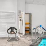 Innenpool mit Dusche, Sauna und Stuhl. Poolbereich mit Aufstiegsleiter.