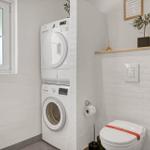 Wohnung mit Waschmaschine, Trockner und Toilette. Fenster, Pflanze und Wandgestaltung.