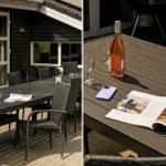 Terrasse mit Tisch, Stühlen, Weinflasche und Zeitschrift.