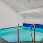 Innere Schwimmhalle mit blauem Becken und Metalltreppe