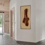 Halle mit Holzwand, Tür zum Außenbereich und Wandbildern.