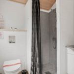 Badezimmer mit Dusche, Toilette und Waschbecken.