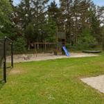 Großer Garten mit Spielplatz, Klettergerüst, Rutsche und Trampolin.