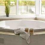 Eine große Whirlpool-Badewanne mit Blick auf den Garten.