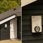 Haus mit dunkler Holzfassade, weißer Tür und elektronischem Türöffner an der Wand.