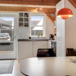 Küche mit Essbereich, weißer Arbeitsfläche, Fenster und Tür zum Außenbereich.