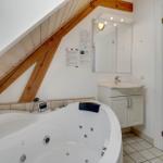 Bad mit Whirlpool, Holzbalken, Waschbecken und Spiegel