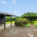 Hinterhof mit Pavillon, Tisch und Stühlen, Grünflächen und Bäumen.