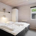 Schlafzimmer mit Doppelbett, weißen Wänden und Fensterblick auf Grün.