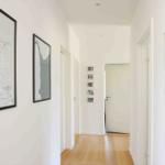 Hallway with wooden floor and wall art, including a map of Odsherred.