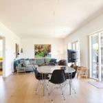Living and dining area with dining table, sofa, and glass doors to the terrace.